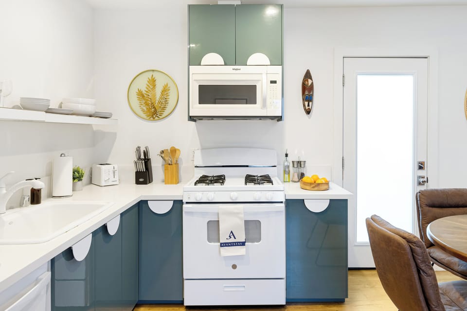 Modern, fully equipped kitchen with gas range, microwave, and stylish open shelving—perfect for easy meals and casual cooking. (Urban Jungle)