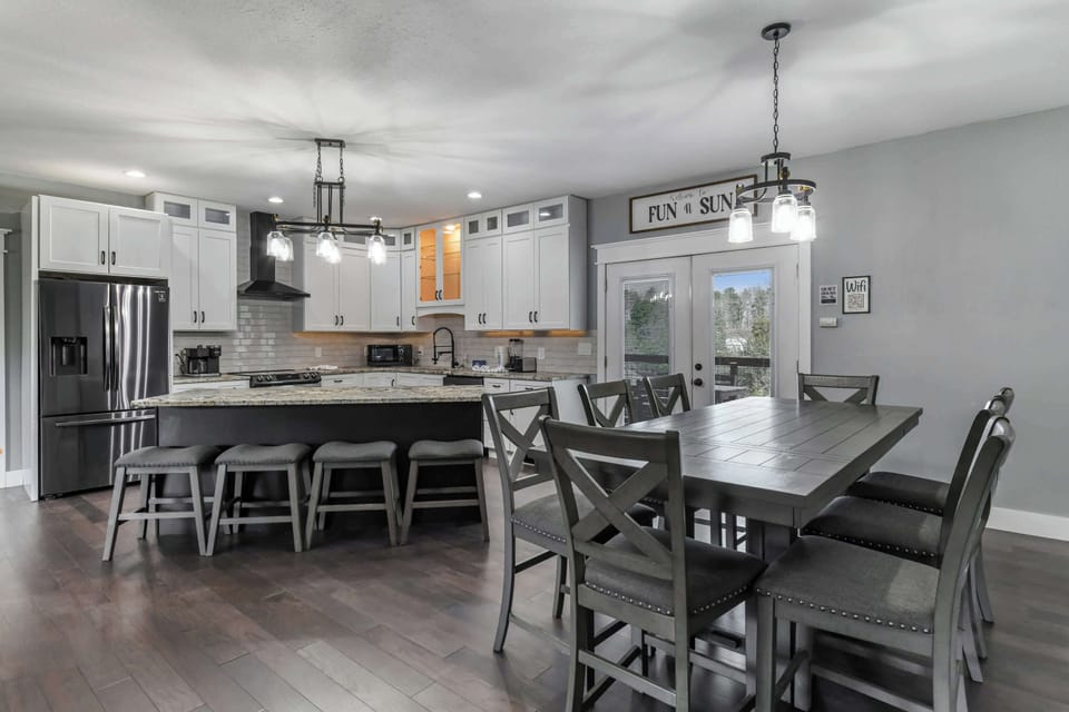 Modern kitchen and dining area with granite countertops and seating for eight.