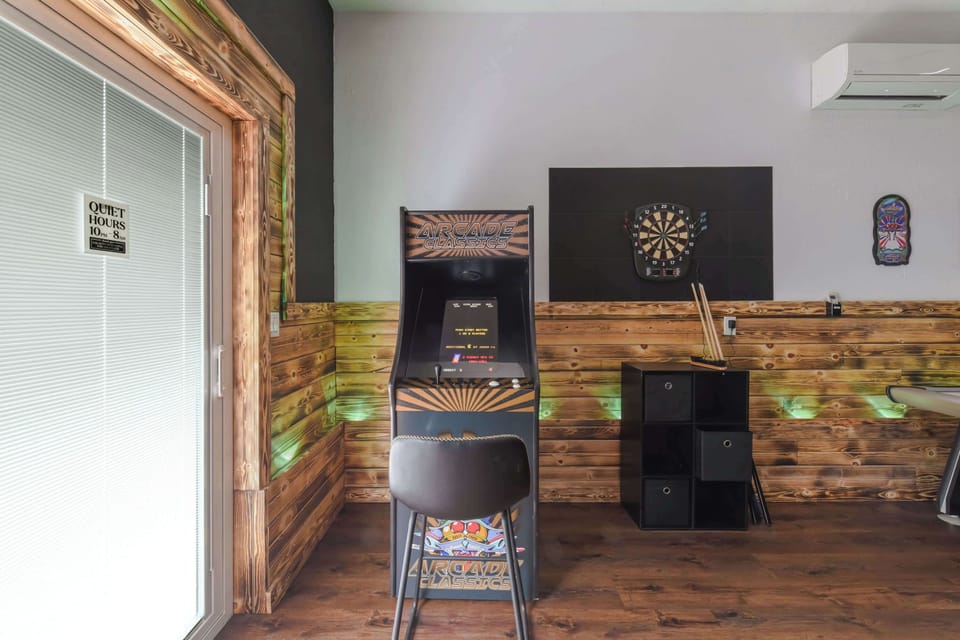 game room featuring a classic arcade machine and a dartboard for entertainment
