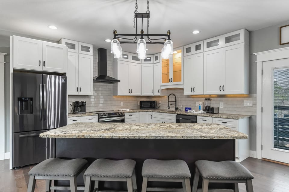 Modern kitchen with granite island and white cabinetry