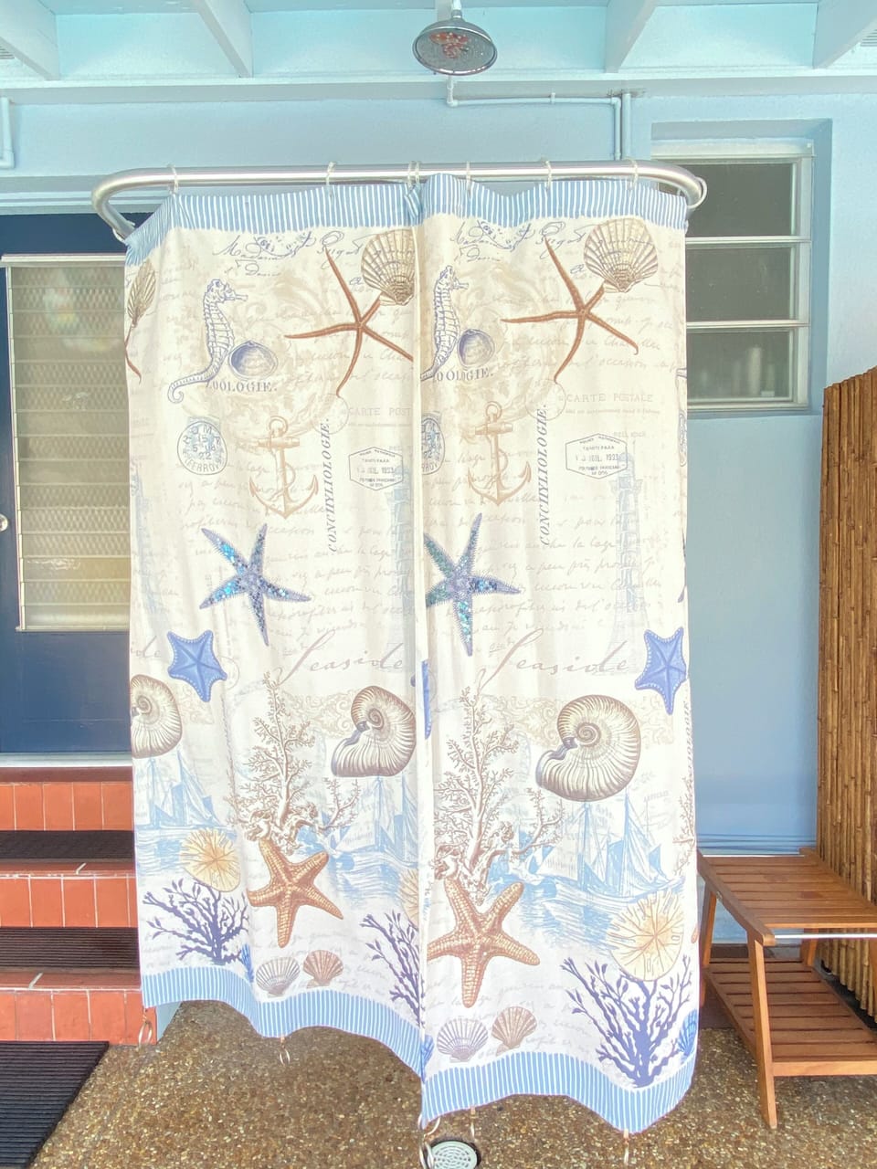 Back porch shower with the curtain closed for privacy, hot and cold water