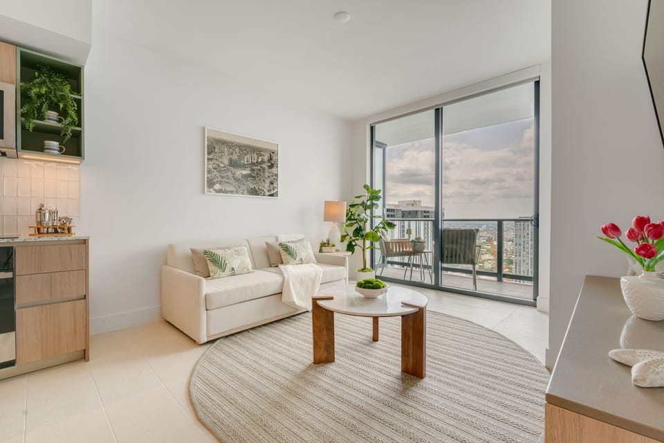 Modern furnishings, calming tones, and cityscape views from your living room.