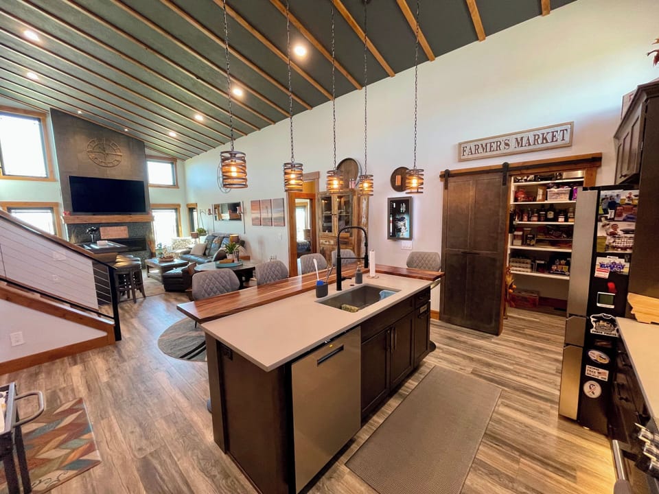 Large kitchen island w/ raised butcher block L-shaped bar.  Large walk-in Pantry