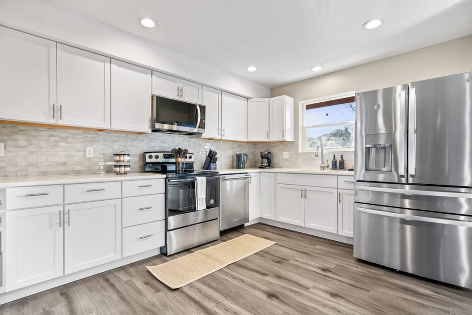 Sleek kitchen with stainless steel appliances, white cabinets, and great light.
