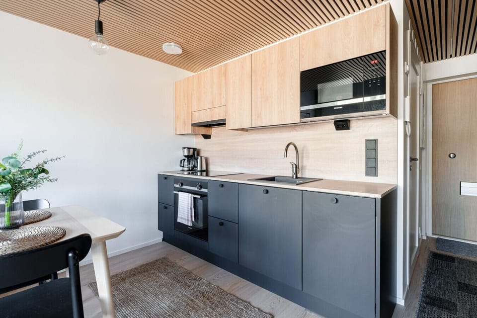This premium open-concept kitchen was fully renovated in 2023 and comes complete with modern appliances, an oven, and a microwave. A dining table for four makes it easy to enjoy home-cooked meals right next to the living area.