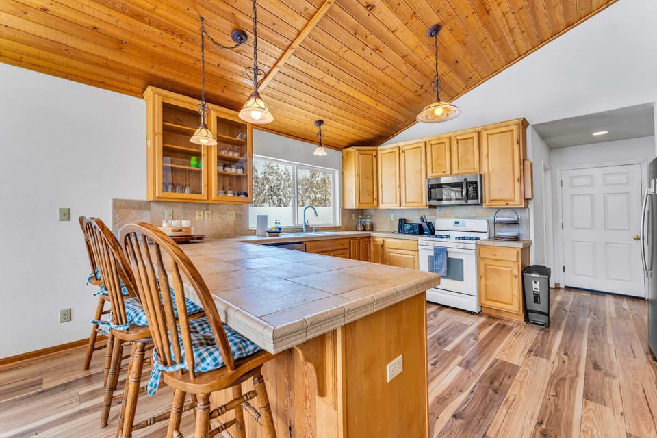 Kitchen: Keurig, drip coffee maker, cooking utensils, tableware, wine glasses, toaster, cutting boards, and knives
