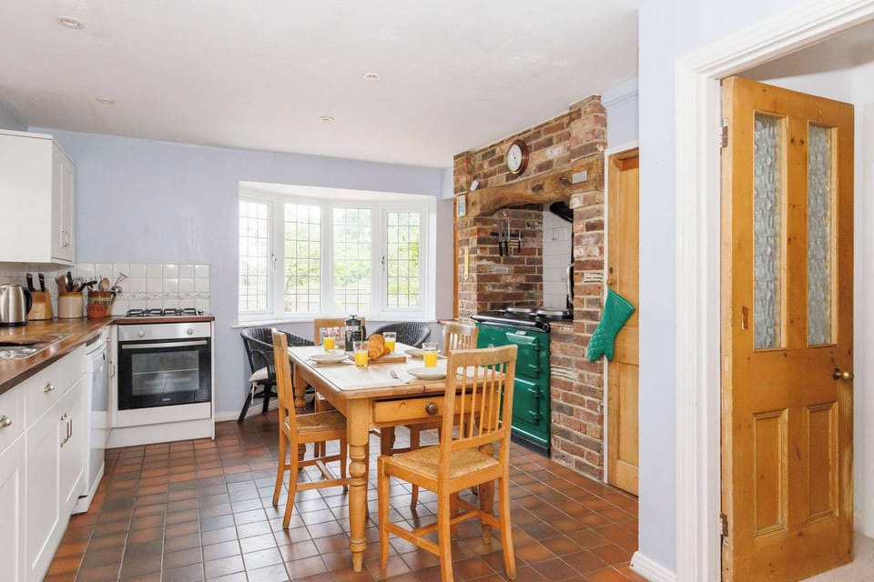 Enjoy a cozy breakfast in this classic country kitchen, complete with a modern oven and a charming Aga for authentic country living.