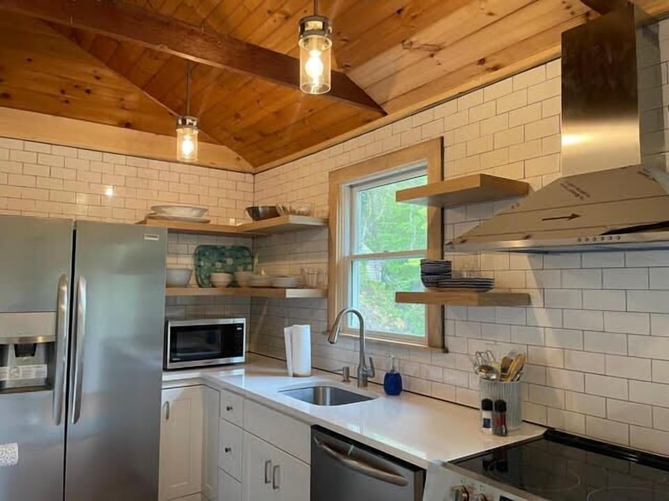 Renovated kitchen with subway tile and wood ceiling