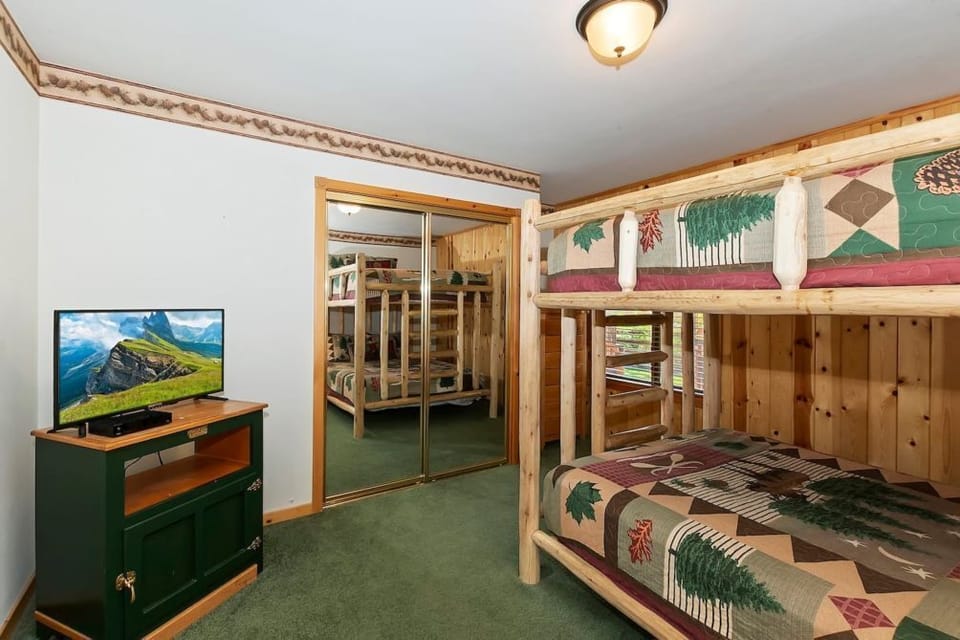 Rustic charm with wooden bunk beds, nature-themed decor, and a mirrored closet