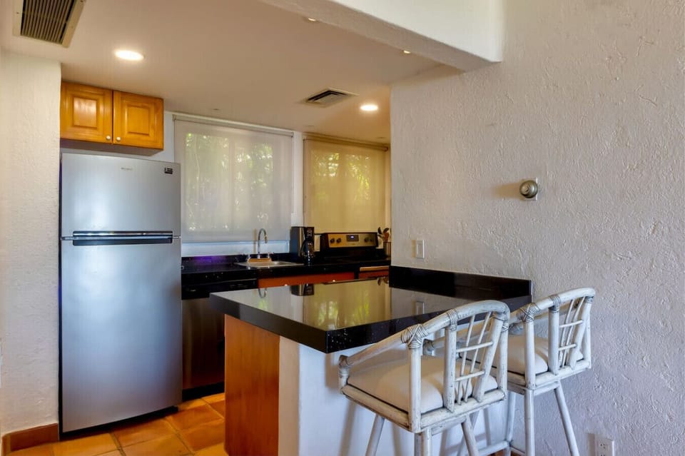 Kitchen with Breakfast Bar – Fully equipped kitchen with modern appliances and bar seating.