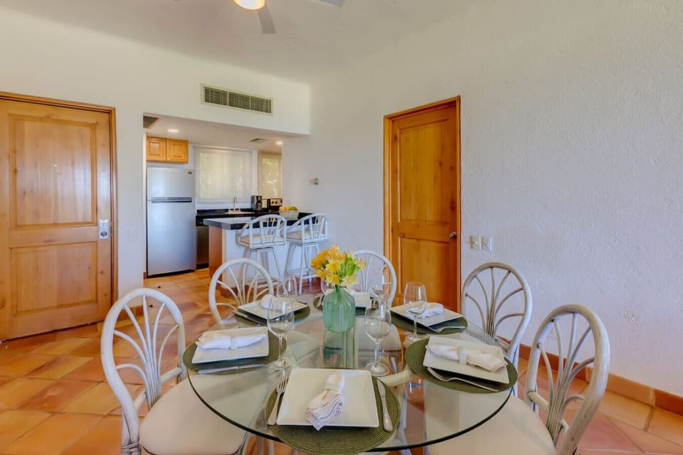 Dining Area – Glass dining table for four with a view into the kitchen.