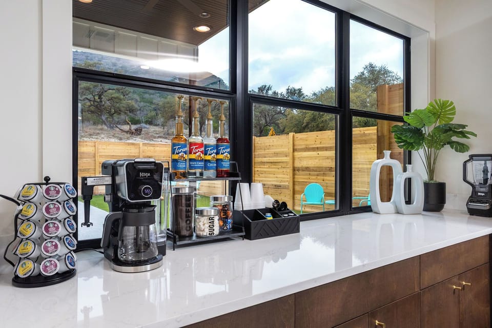 Fully stocked coffee bar with k-cups, ground coffee, hot cocoa, creamer, and flavorings.