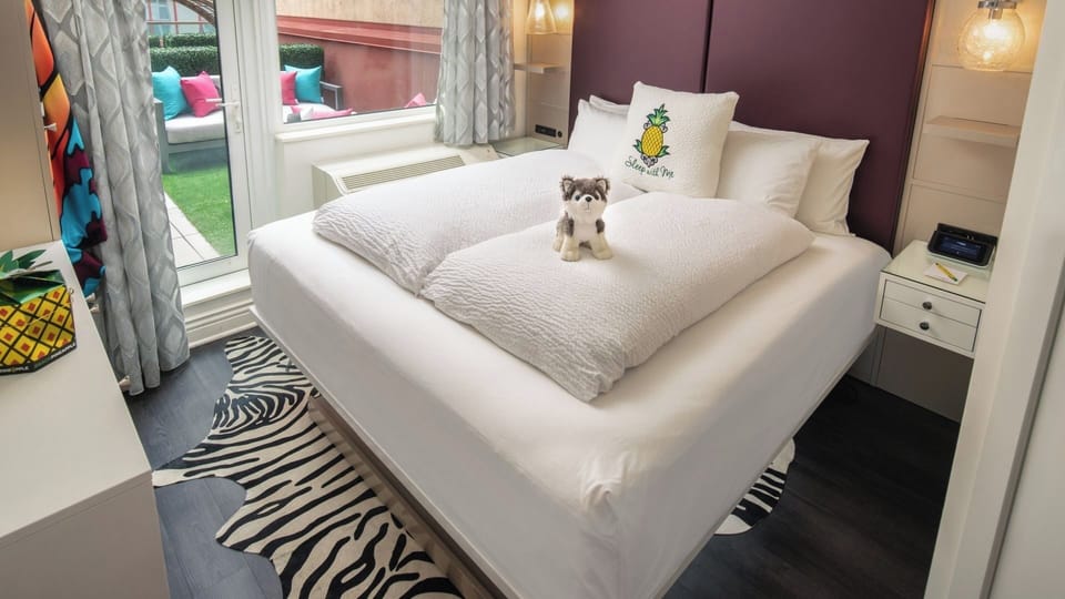 Drift off in crisp linens beside bright patio doors.