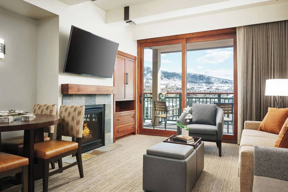 Spacious living area with a sleeper sofa and door to the private balcony. Dining are off the side of the kitchen.