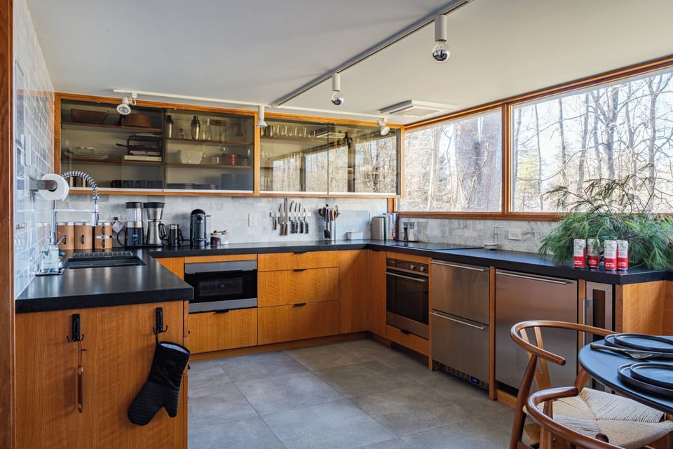 Enjoy the classic mid-century kitchen, complete with picture windows looking out onto the surrounding forest.