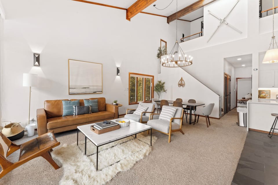 Living area featuring ample seating, flat-screen TV, wood burning fireplace, and balcony access.