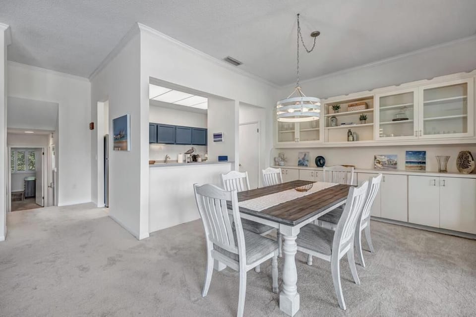 - Farmhouse style dining room with seating for six and built in display shelving
- Open view to the kitchen and easy access to living room makes serving meals a breeze
- Nautical themed decor and pendant lighting complete the charming setup