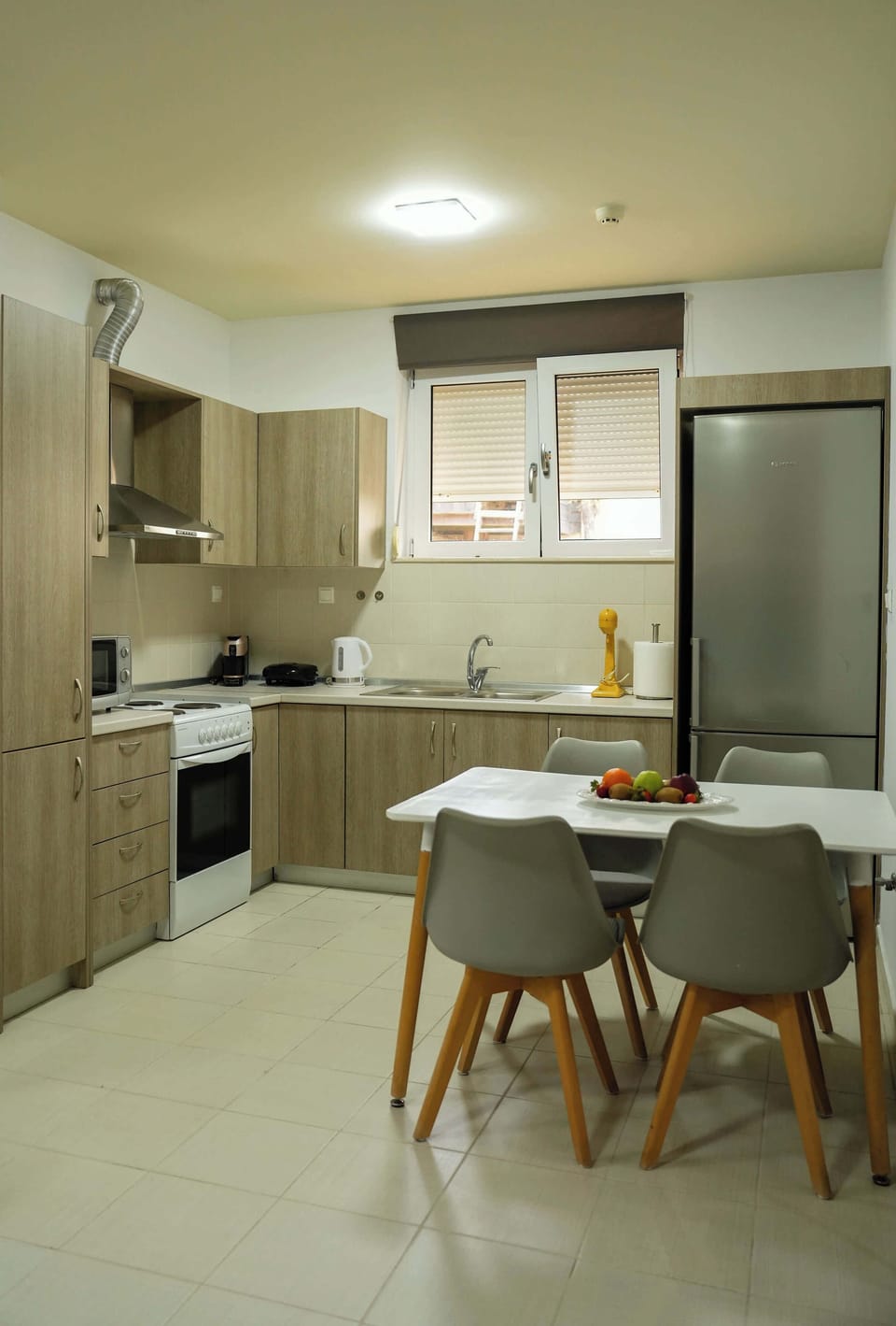 Kitchen & Dining Area – Fully Equipped Setup
Functional kitchen and adjacent dining space with full amenities including refrigerator, oven, and dining table.