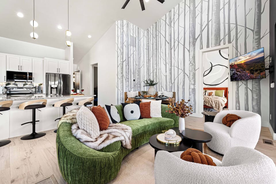 Chic family room with cozy swivel chairs, smart TV, plush couch, mural and views