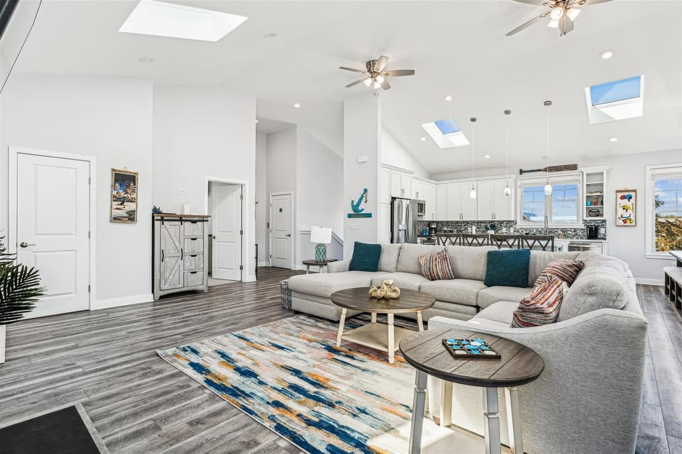 Unwind in your bright, open living space with soaring ceilings, skylights, and a comfy sectional perfect for movie nights.