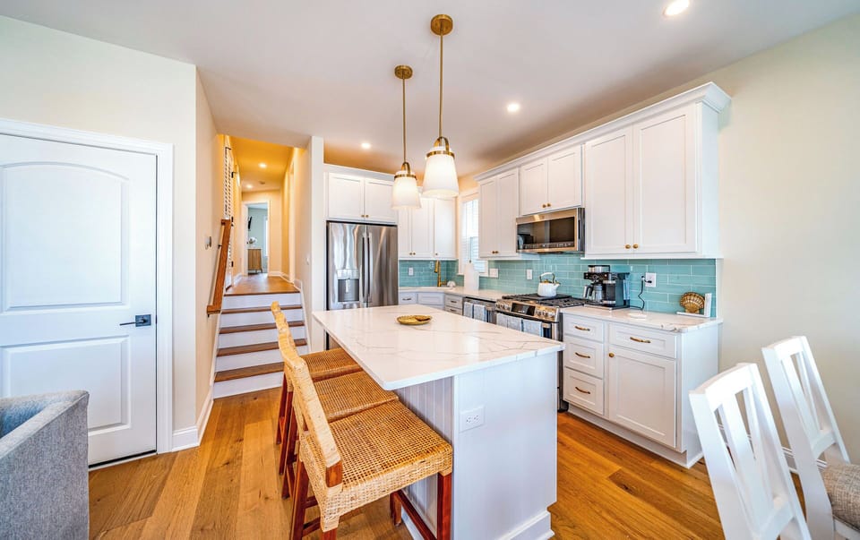 Kitchen area and kitchen island which can seat three
