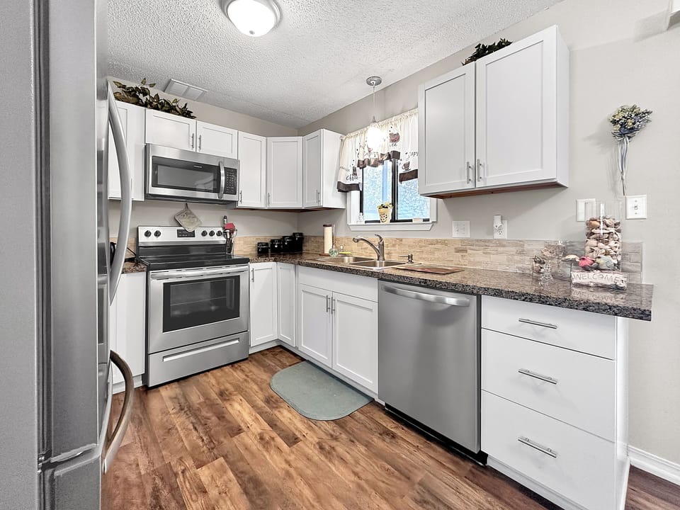 Fully stocked with pans, cutlery, dishes, cups, glasses and silverware.