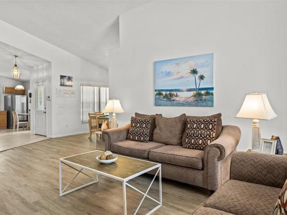 Expansive living area with a flat-screen TV, seamlessly blending comfort and style while overlooking the beautiful pool and spa.