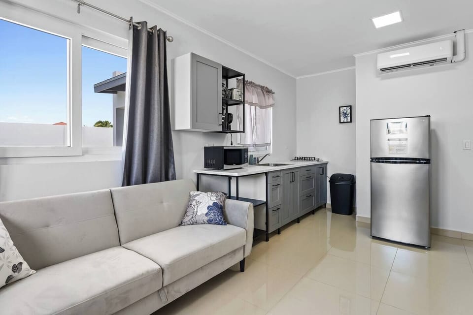 Open living space with a cozy sofa and modern kitchen.


