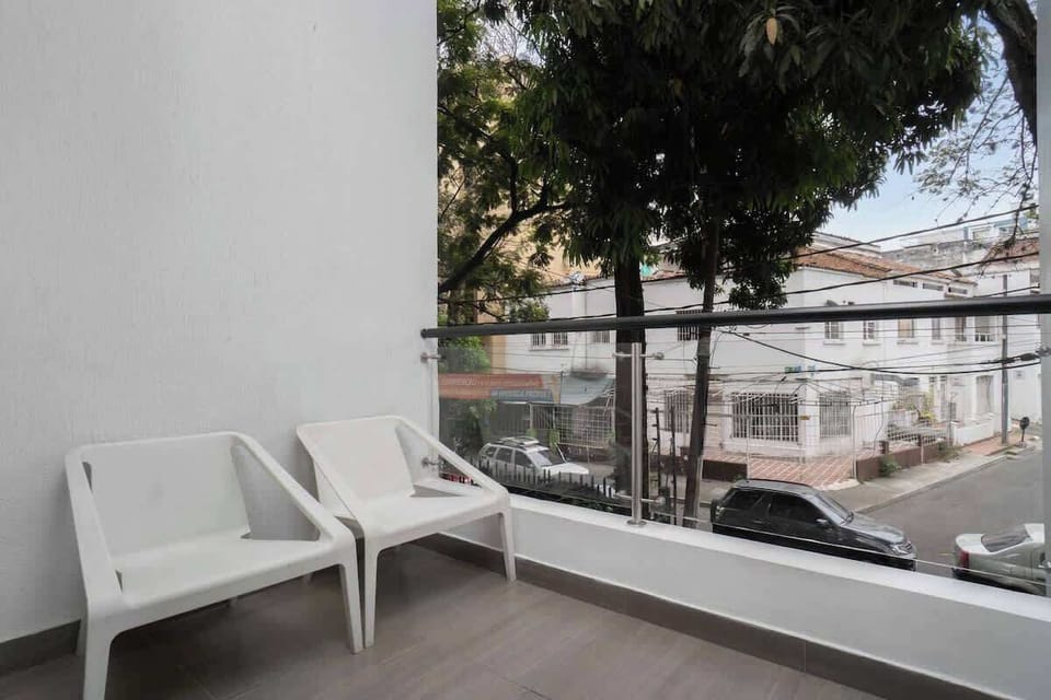 Balcony with 2 chairs and view of the street. 