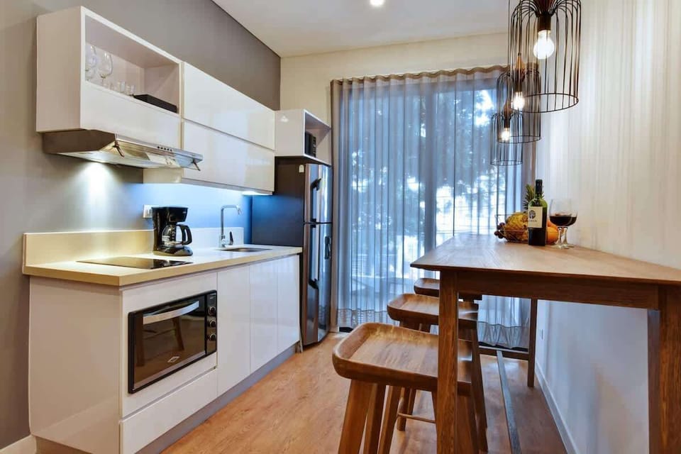 Kitchen and bar with full size fridge. A blackout has since been installed behind the curtain so you can block out all light if needed. 