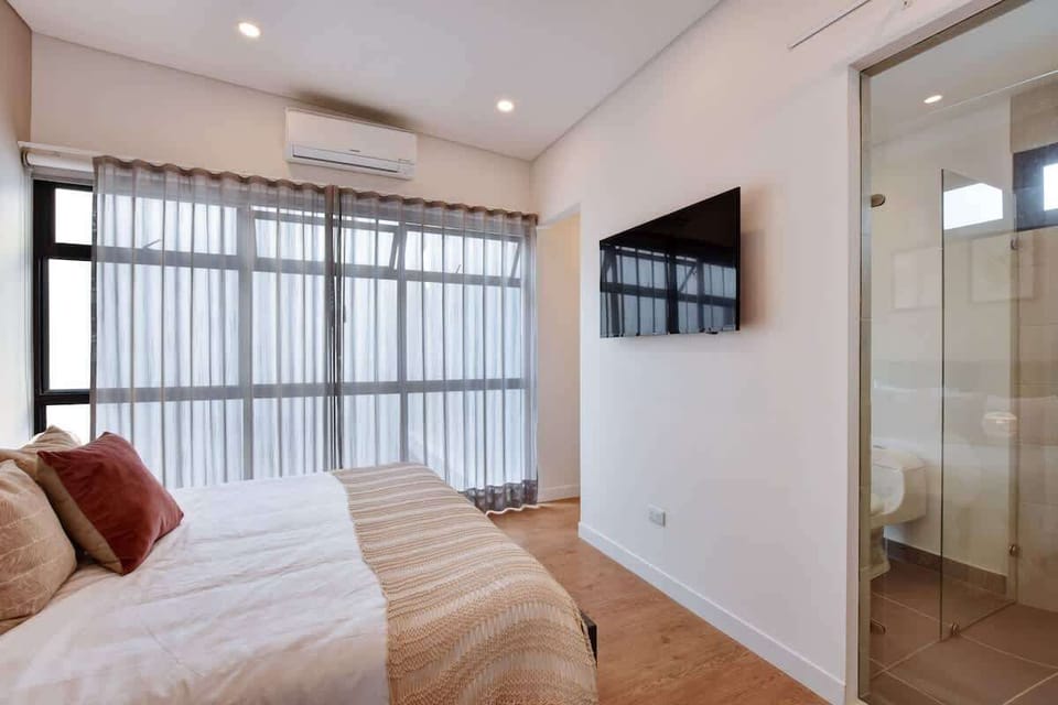 Large bedroom with A/C, smartTV and access to private bathroom. Window has curtains and blackouts as well.