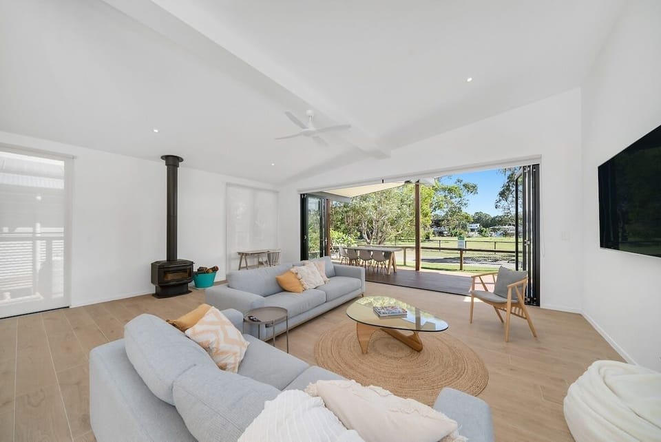 Open space opens to the outdoors with folding doors, lounges, a modern kitchen.