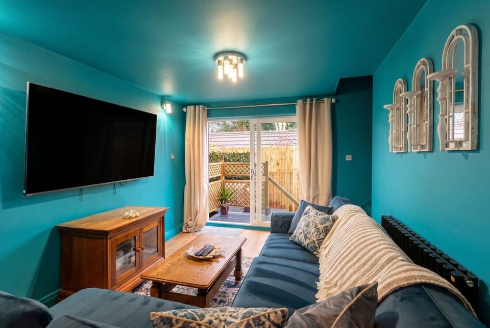 A bold teal snug with garden doors makes the perfect unwind spot.