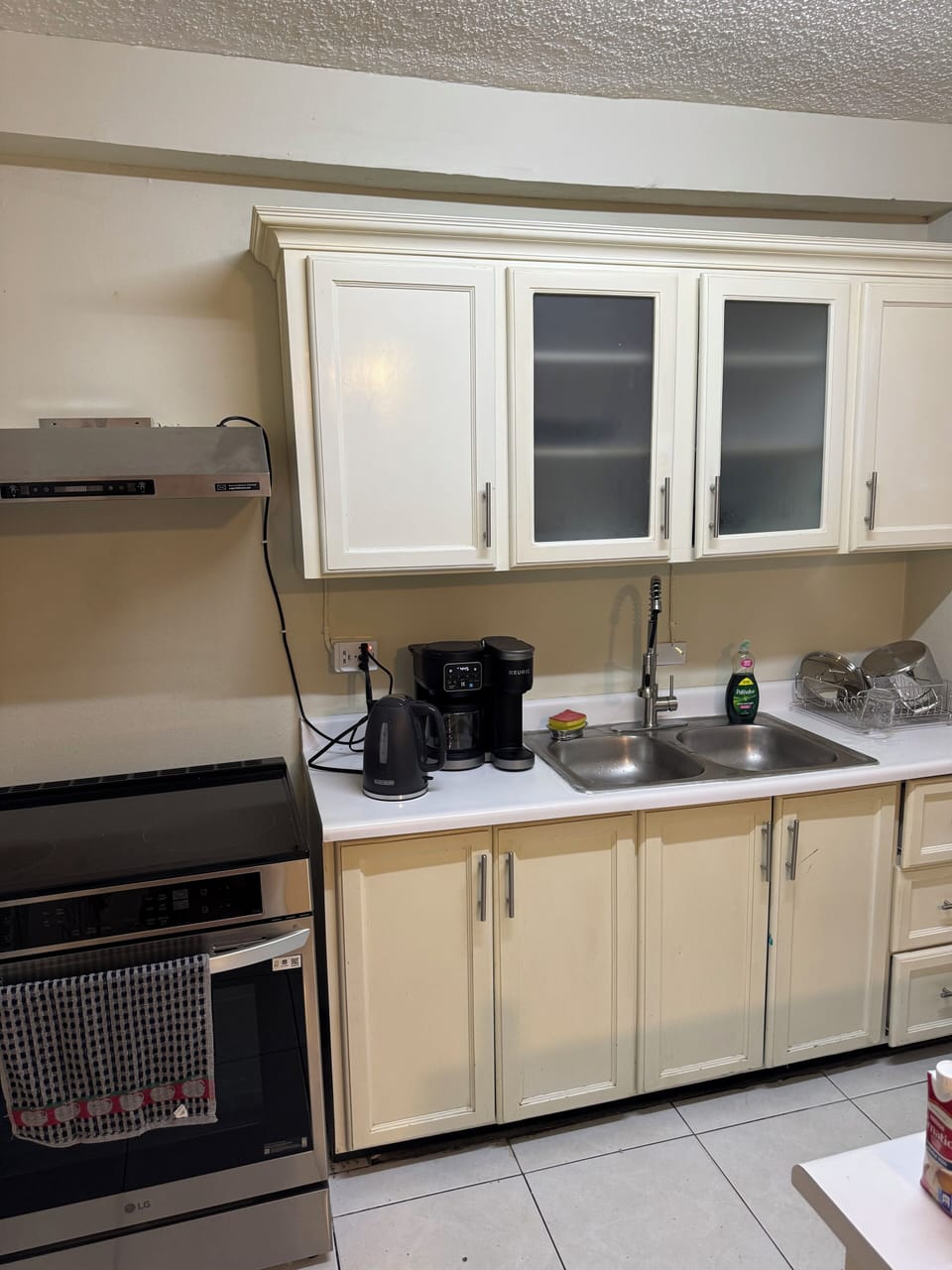 Coffee maker and electric kettle along with electric stove with air ventilation.