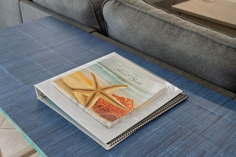 A beach-themed book on the table adds a relaxed, coastal vibe to the room. Its vibrant images of sandy shores, ocean waves, and tropical landscapes can inspire a sense of tranquility and adventure, bringing the feeling of the beach into the space. It`s a 