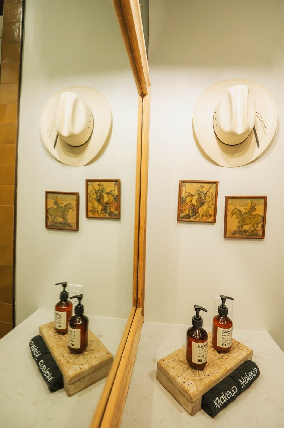 A closer look at the Corral Suite vanity — modern Western fixtures, a lit mirror, and curated bath amenities, all en-suite.