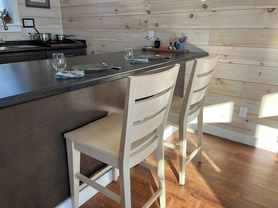 Bright kitchen with white chairs at the bar, perfect for coffee or cozy dinners for two.