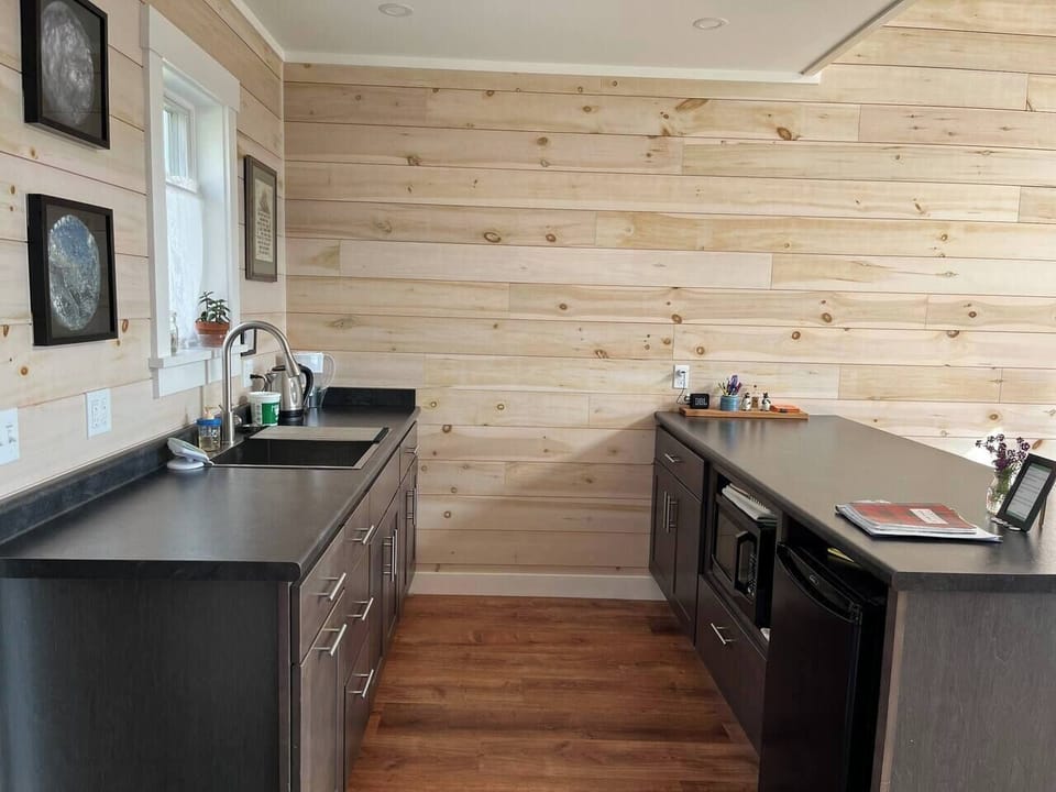 Cozy kitchen with sink, fridge, and mason jars—perfect for morning coffee or evening wine.