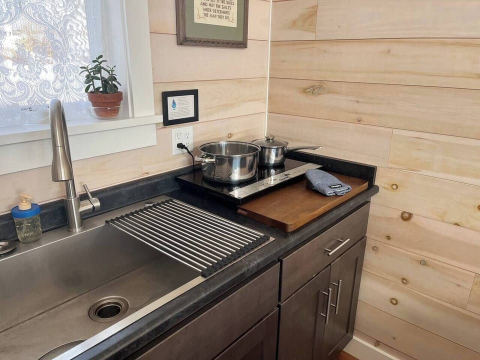 Charming kitchenette with induction cooktop, pots, pans, and all you need for culinary adventures.