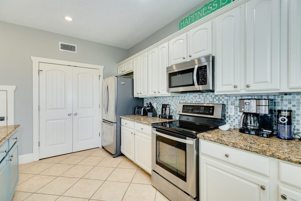 Everything you need for preparing meals, storing your food and drinks, and the laundry room is just behind the double doors