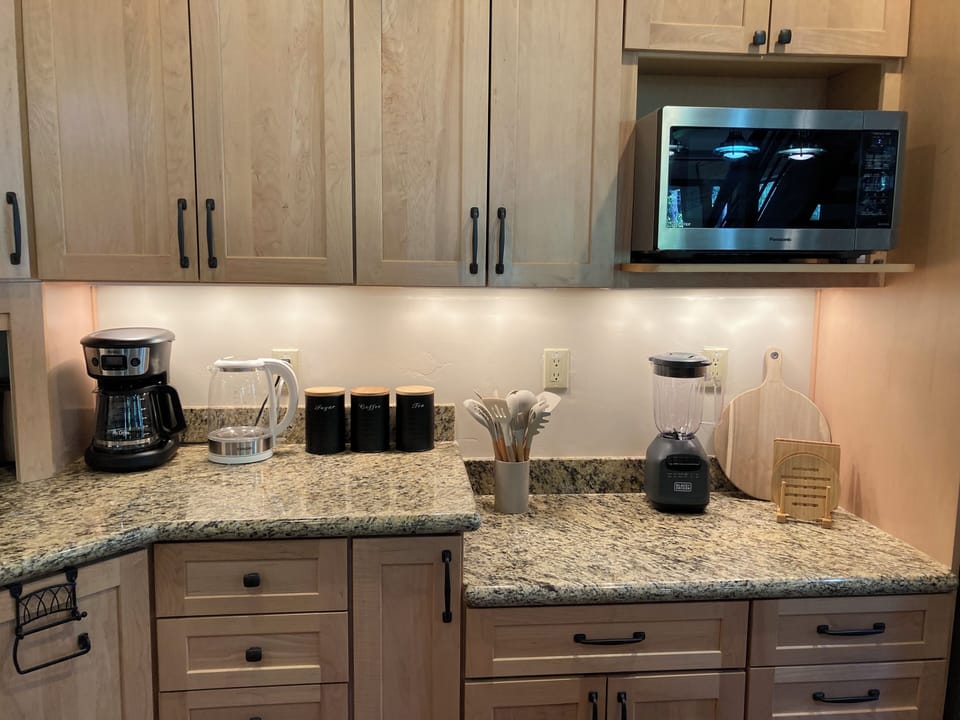 Kitchen appliances include coffee maker, kettle, blender and microwave