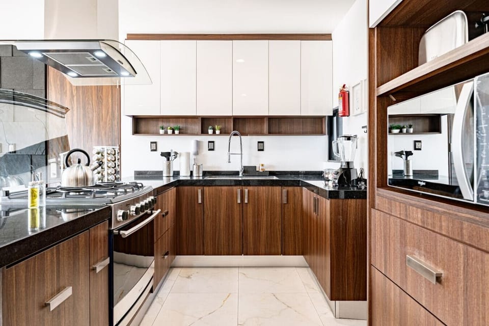 Modern kitchen with microwave, oven, and large refrigerator for home cooking