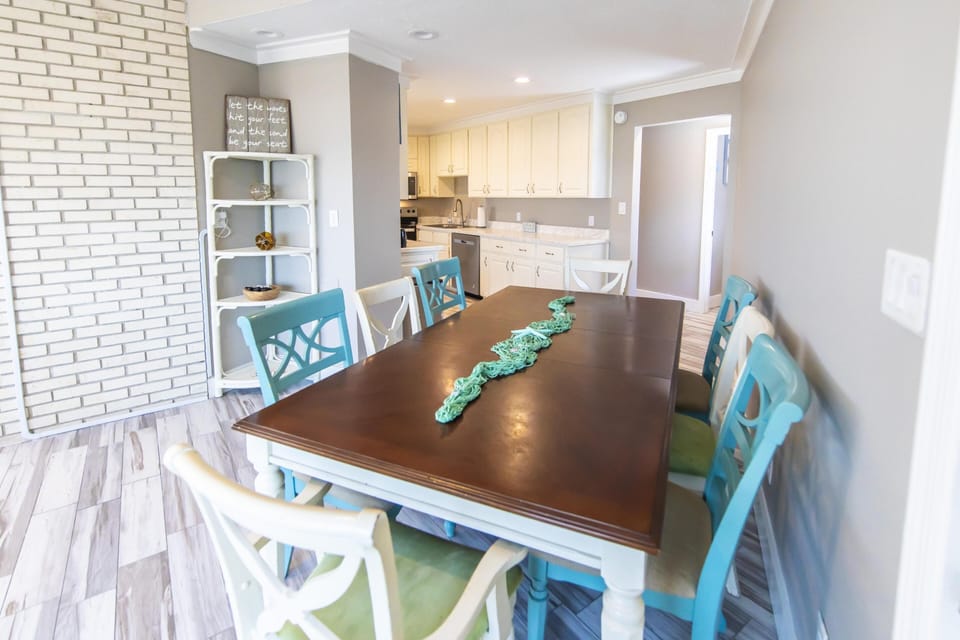 Bright dining area with colorful chairs and open kitchen view