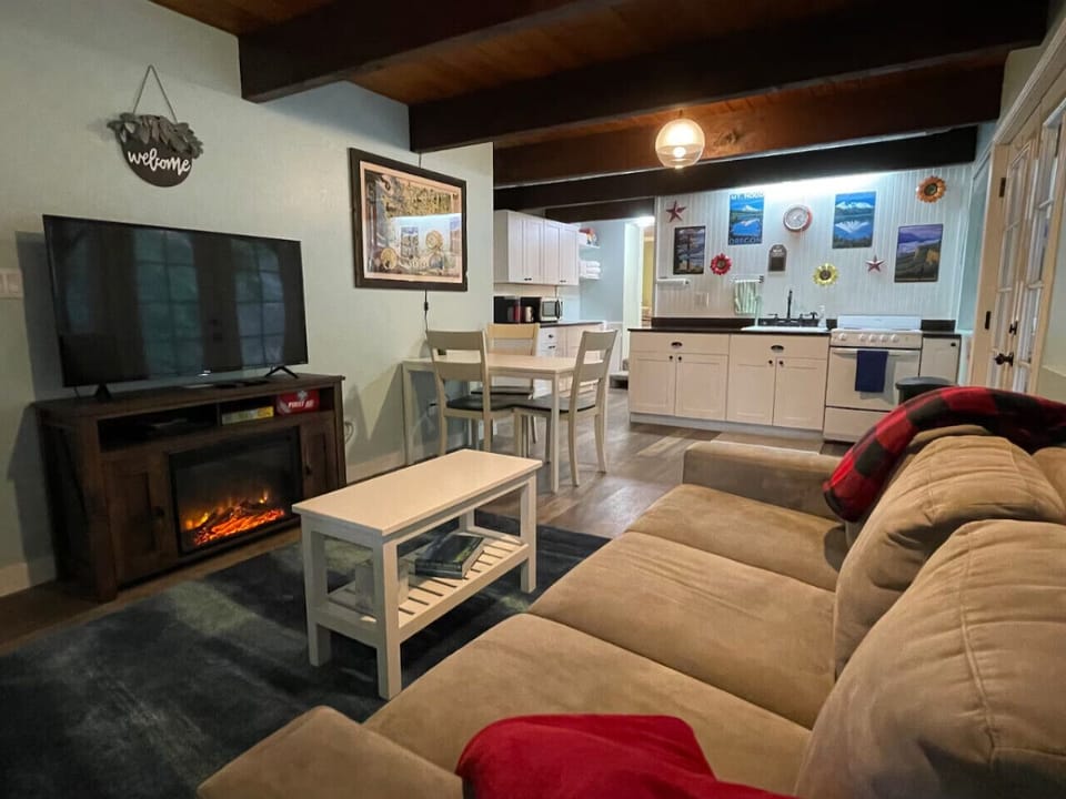 Lower Level Main room. Electric fireplace with remote and Smart TV. Dining table seats four, or insert leaf to seat up to six. Coffee table works as bench, folding chairs also provided.