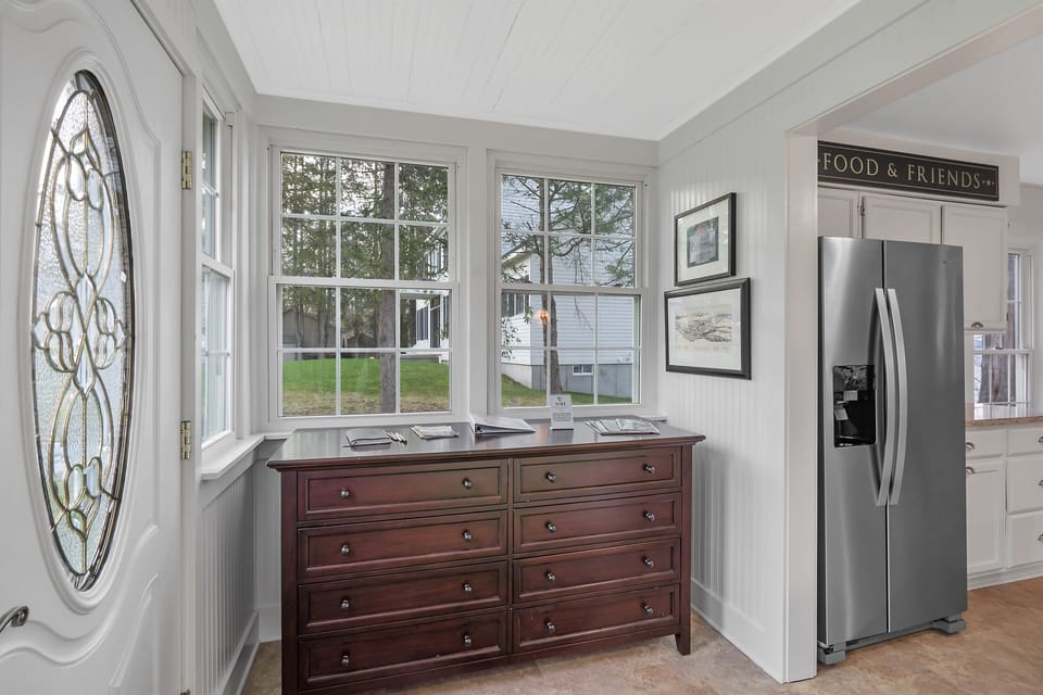 The entryway connects the kitchen to the sunroom, featuring tasteful décor and abundant natural light.