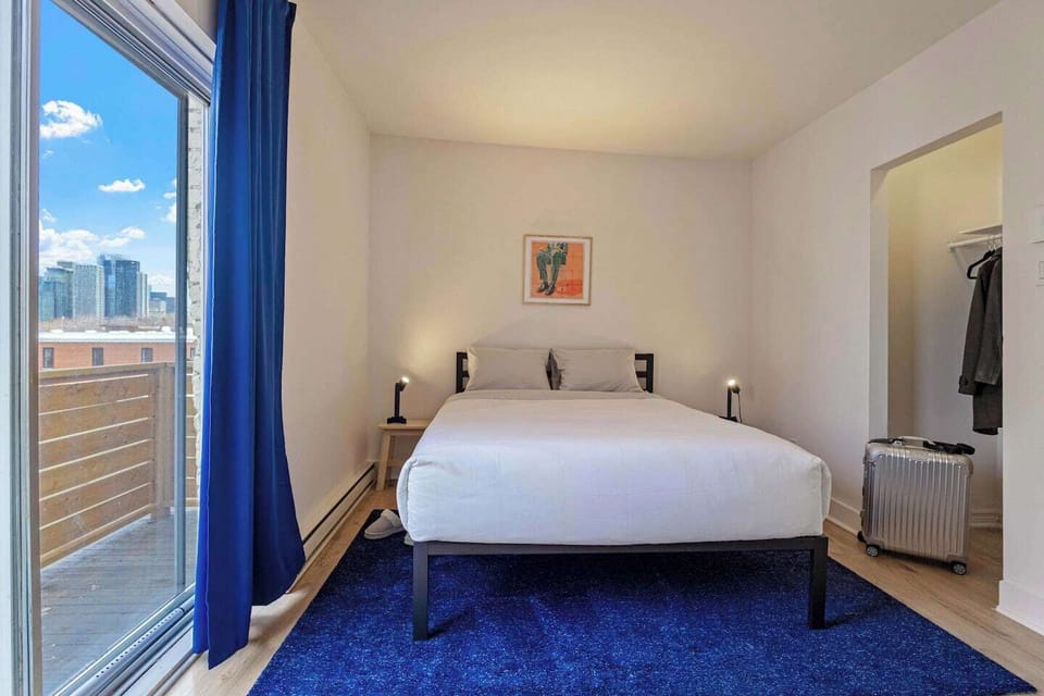 Wake up to stunning city views in this bright and modern bedroom. Featuring a plush queen-size bed, a private balcony, and elegant décor, this space is perfect for relaxation. Enjoy natural light, a cozy atmosphere, and easy access to the heart of the city.