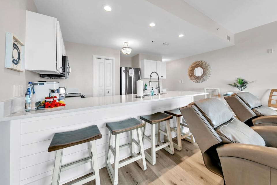 Gather around the spacious breakfast bar where you can enjoy morning coffee and casual meals together in this bright, modern kitchen.