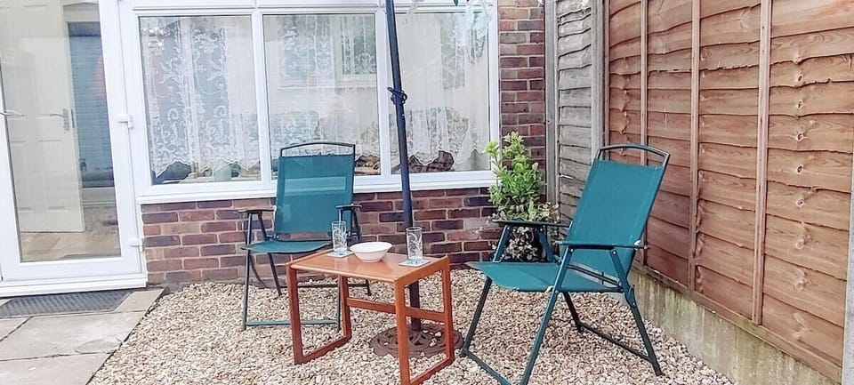 Sheltered and private south facing gravel garden with chairs and sun parasol for guest use. 
