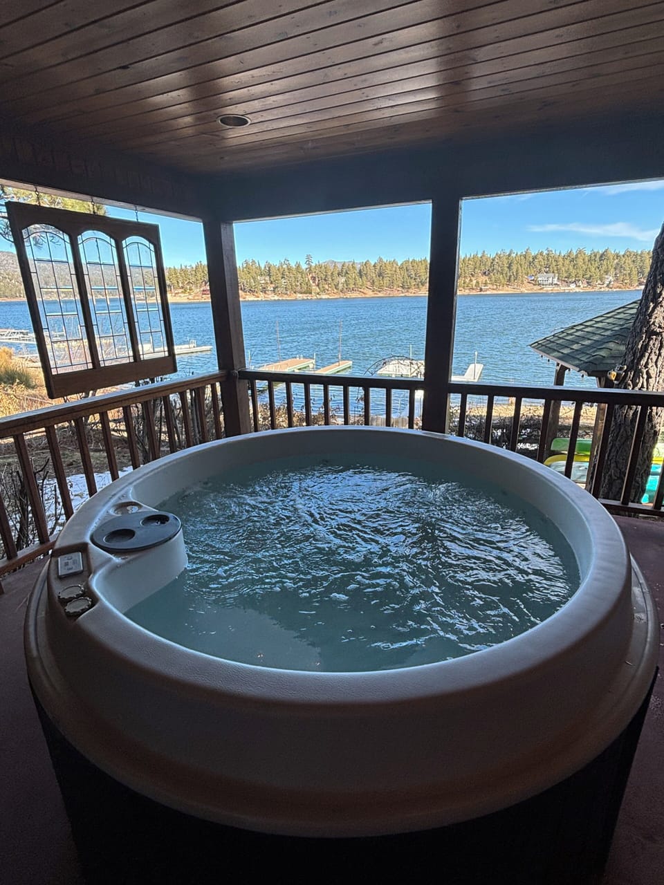 Hot tub outside primary bedroom sits on protected deck for year round enjoyment