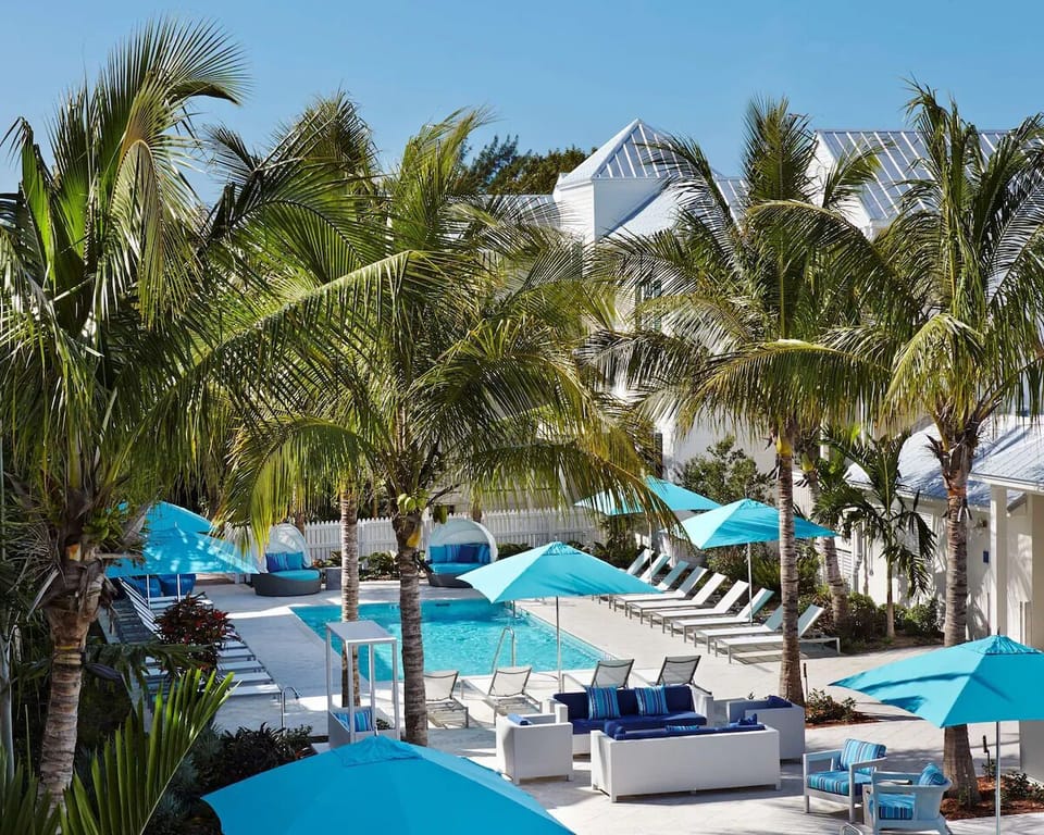 Stretch out on sun loungers beneath swaying palms and shade.